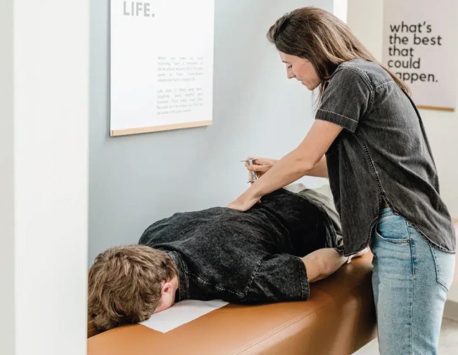 Chiropractor administering Torque Release Technique adjustment to a patient on a treatment table in a modern clinic setting.