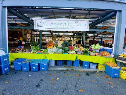Cedarville Farm produce stand at Bellingham Farmers Market showcasing fresh vegetables and fruits.