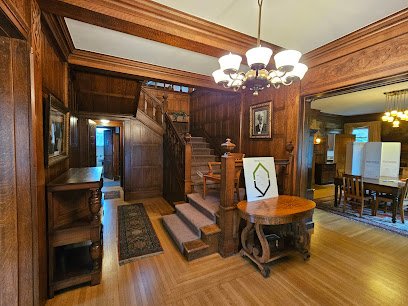 Historic Roeder Home interior featuring wooden paneling, staircase, and dining area, located in Bellingham, showcasing local architectural heritage.